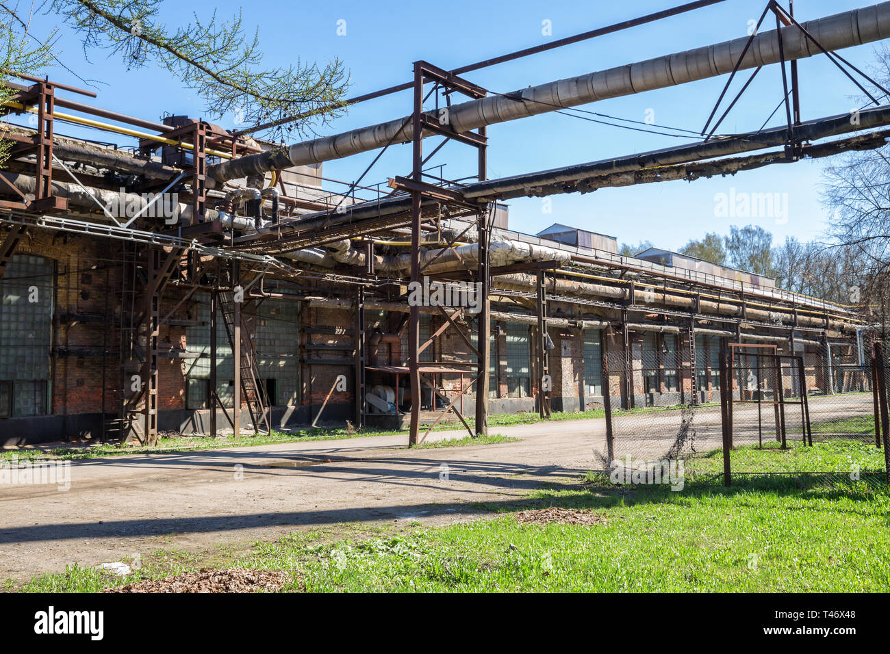 Industrie. Alte Werkstätten der Izhora Pflanzen, ein Backsteingebäude mit einer Pipeline Stockfoto