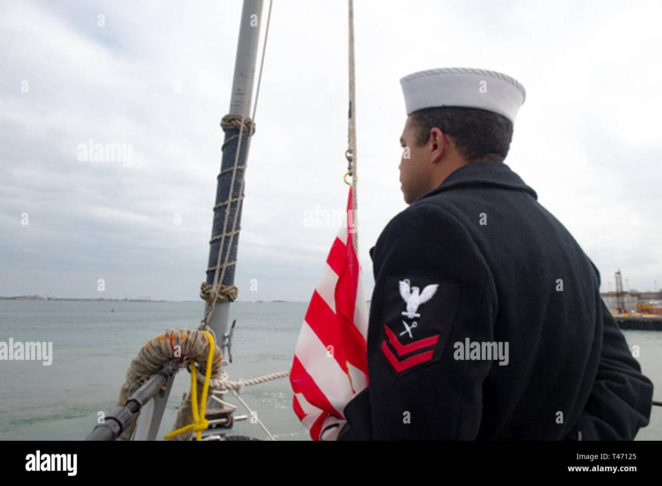 BOSTON (Mar. 14, 2019) das Schiff Veteran 2. Klasse Marquise Ball, ein Eingeborener von Norfolk, Virginia, erwartet die Navy Jack an der Hebevorrichtung an Bord der Arleigh-Burke-Klasse Rakete Zerstörer USS Jason Dunham (DDG109). Dunham ist in Boston in der St. Patrick's Day Veranstaltungen teilzunehmen. Stockfoto