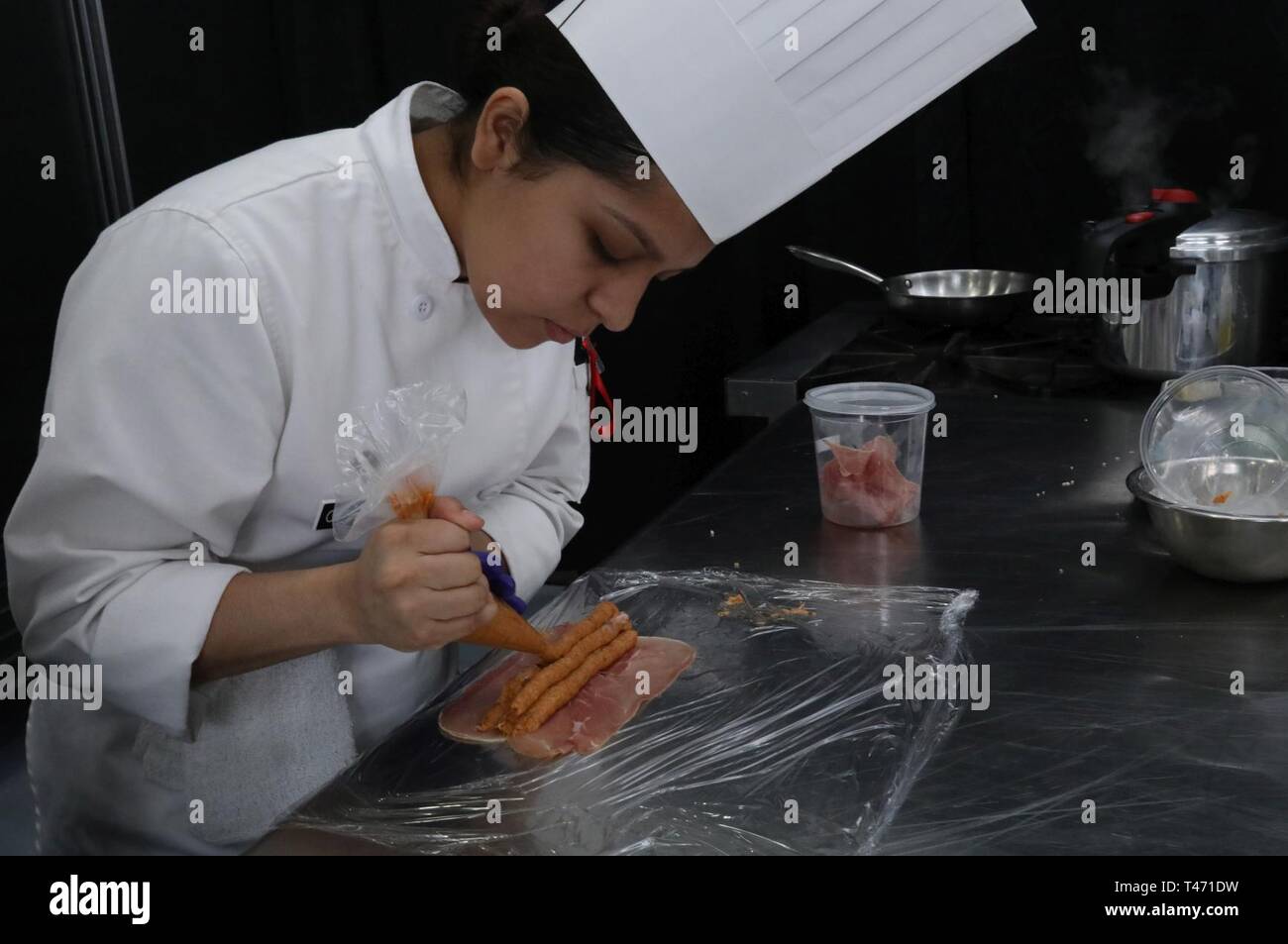 Spc. Angela Calderon, kulinarische künste Spezialist, Team Hawaii, Rohre eine Mischung auf dünn geschnittenen Schinken als Teil des student Team Event 14. März als Teil der Gemeinsamen kulinarischen Training Übung (JCTE) am Fort Lee, Va. Im Falle, das fünfköpfige Team, mit weniger als zwei Jahren Erfahrung, bereiten Sie ein 3-Gänge-Menü. Die 44. jährliche JCTE offiziell gestartet 9. März an MacLaughlin Fitnesscenter und wird bis zum 14. März. Die Übung, die von der Gemeinsamen kulinarischen Kompetenzzentrum verabreicht, der größte amerikanische kulinarischen Vereinigung - sanktionierte Wettbewerb in Nordamerika. Die Ausübung showca Stockfoto