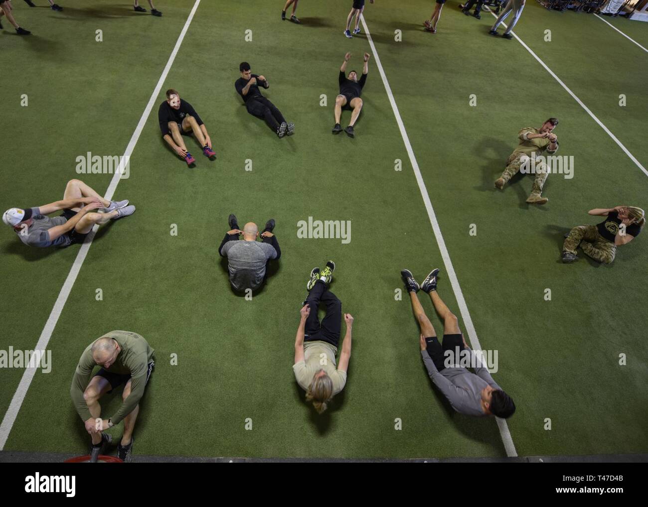 Ein Team in der maltz Herausforderung Beteiligten durchführen, Sit-ups in Kirtland Air Force Base, N.M., 15. März 2019. Die maltz Herausforderung ist eine zeitlich begrenzte, Team Wettbewerb besteht aus einem 400-Meter-Lauf 50 Pull-ups, 100 Yard Feuerwehrmann, 50 Dips, 100 Push-ups, 50 Knie- Ellenbogen, 100 Sit-ups und weitere 400 Meter laufen. Stockfoto