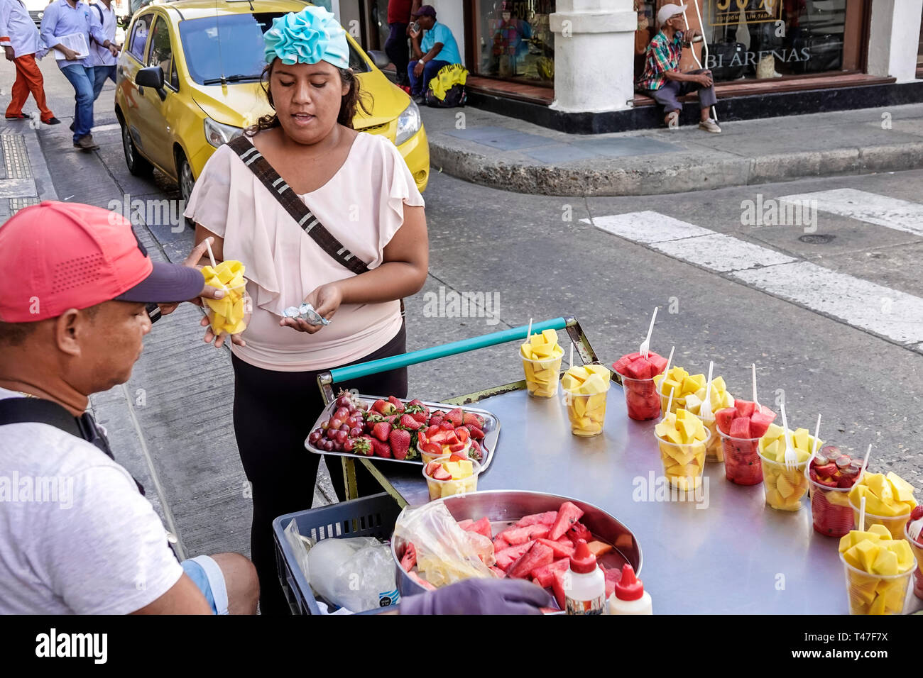Cartagena Kolumbien, Einwohner von Hispanic, Einwohner, Mann, Männer, Straßenverkäufer, Obst, Frau, Frauen, Zahlung von Kundentransaktionen, Schneiden von Obstbechern, Stockfoto