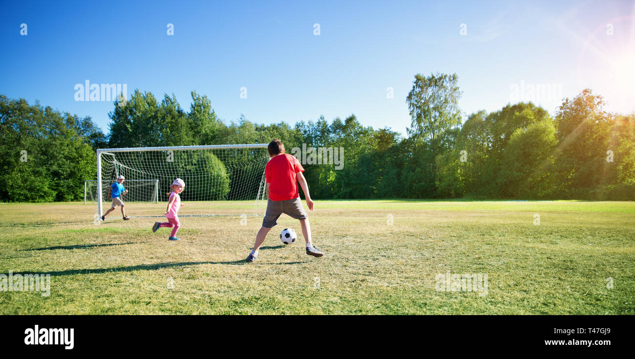 Jungen Fußball spielen auf dem Feld mit Toren Stockfoto