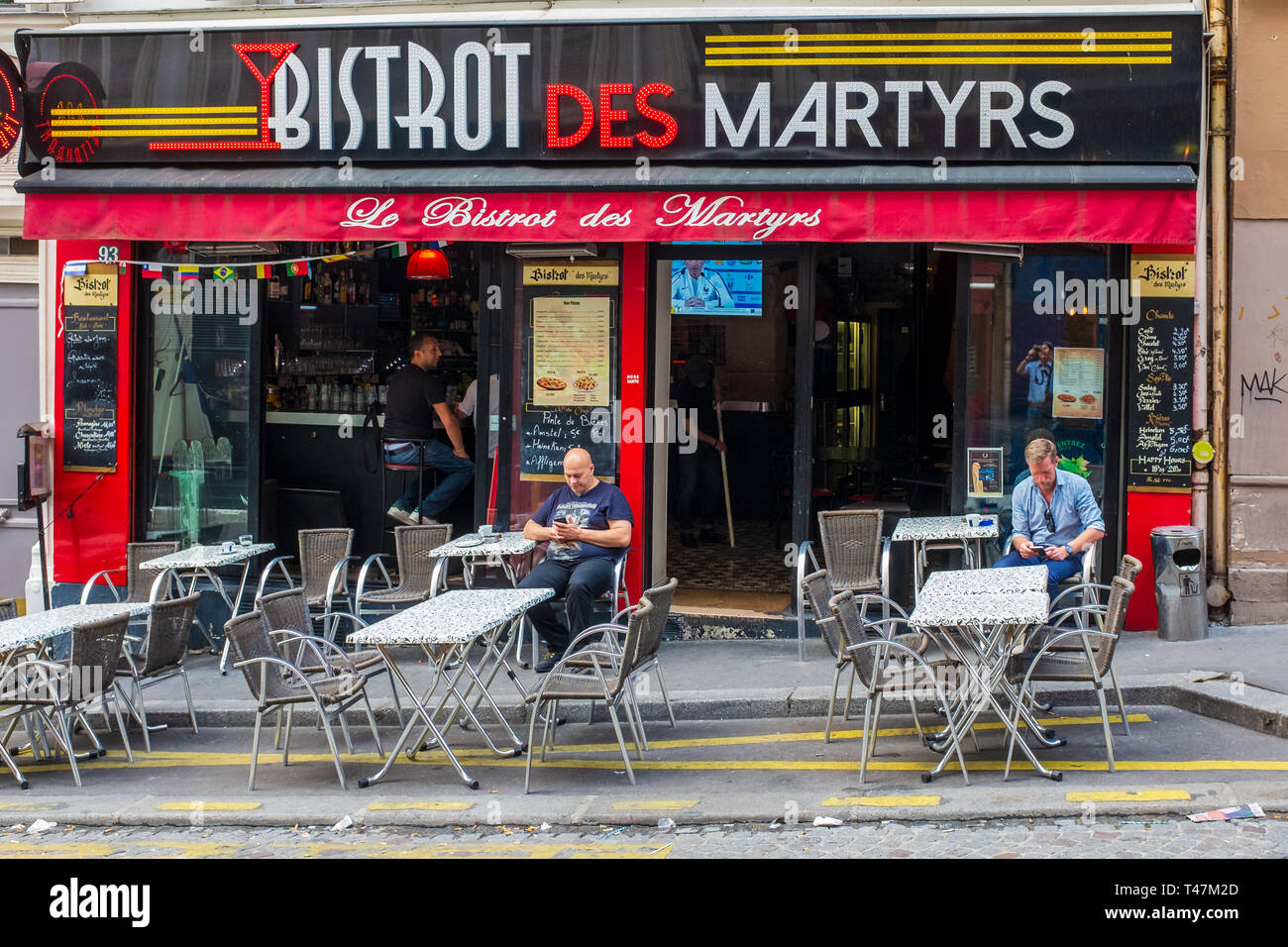 PARIS, Frankreich/Juli 7, 2018: Kunden ihre Handys prüfen, wie sie in der unglaublich - genannt, Bistro des Märtyrer in Montmartre, Paris warten. Stockfoto