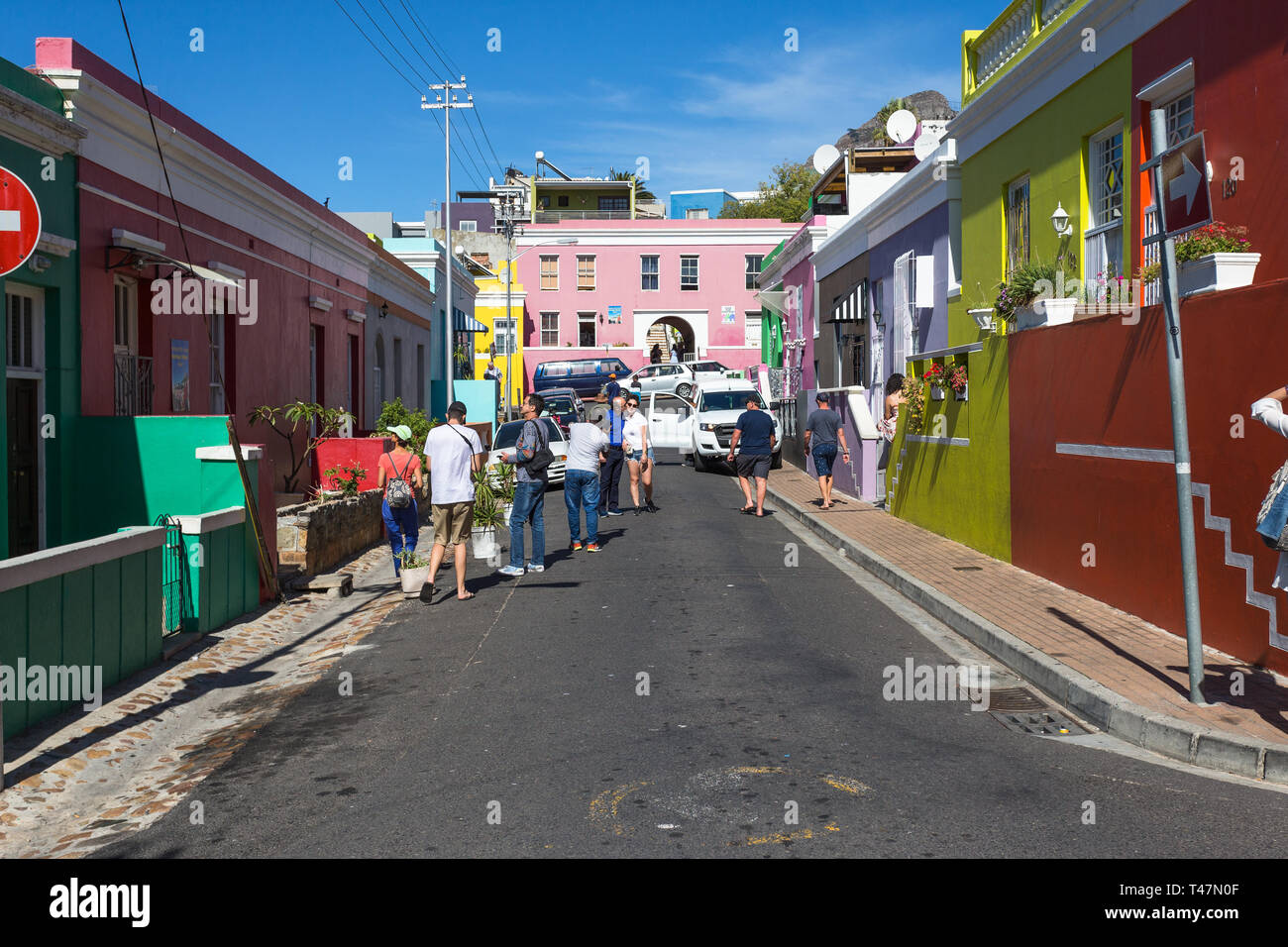 Gruppe oder Menge von Touristen oder Menschen auf der Straße oder auf der Straße außerhalb der bunten Häuser des historischen Wohngebiet von Bo Kaap in Kapstadt Stockfoto