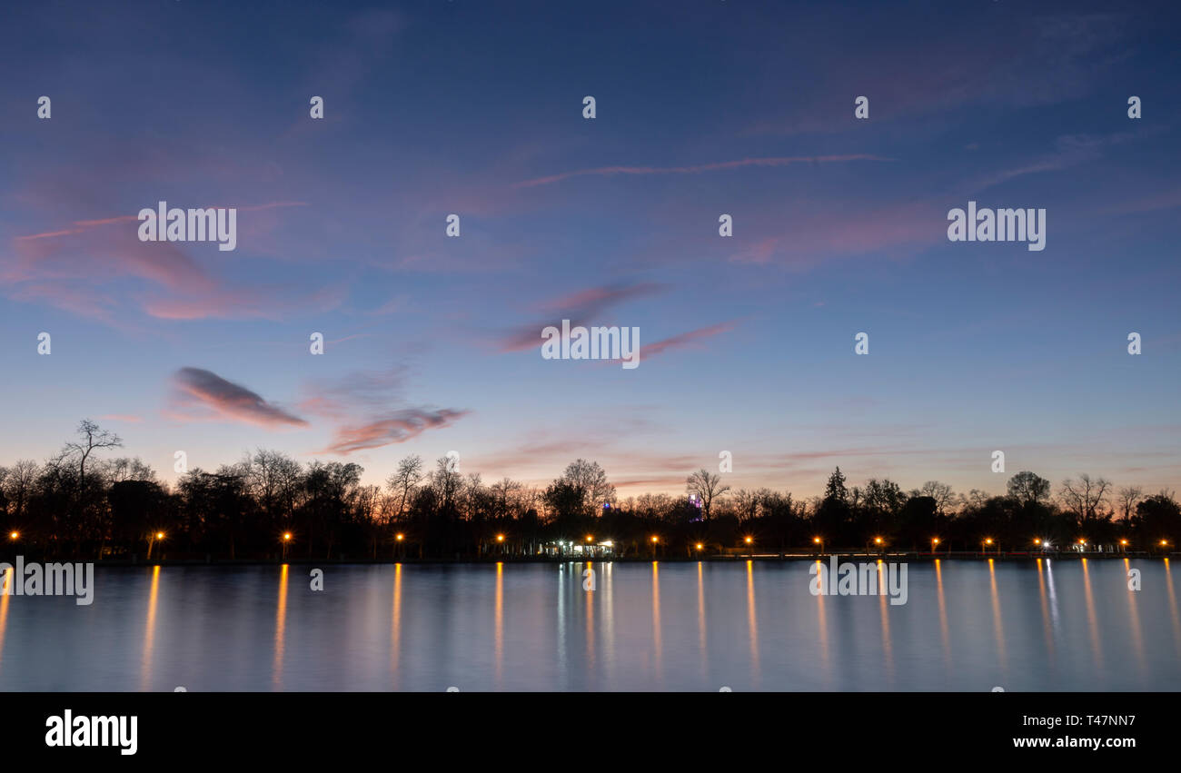 Teich von Retiro Park beleuchtet bei Sonnenuntergang Stockfoto