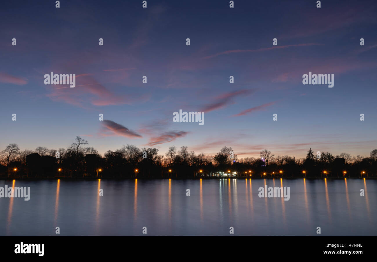 Teich von Retiro Park beleuchtet bei Sonnenuntergang Stockfoto