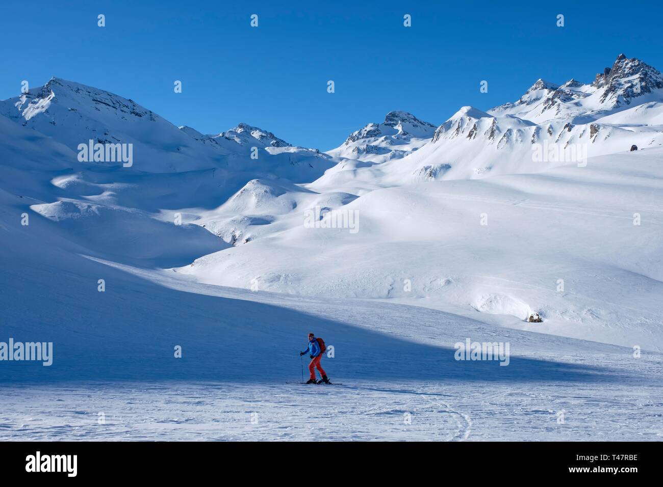 Skitourengeher aufsteigend Ils Chalcogens, im Hintergrund der Piz Tasna und breite Krone, Graubünden, Schweiz Stockfoto
