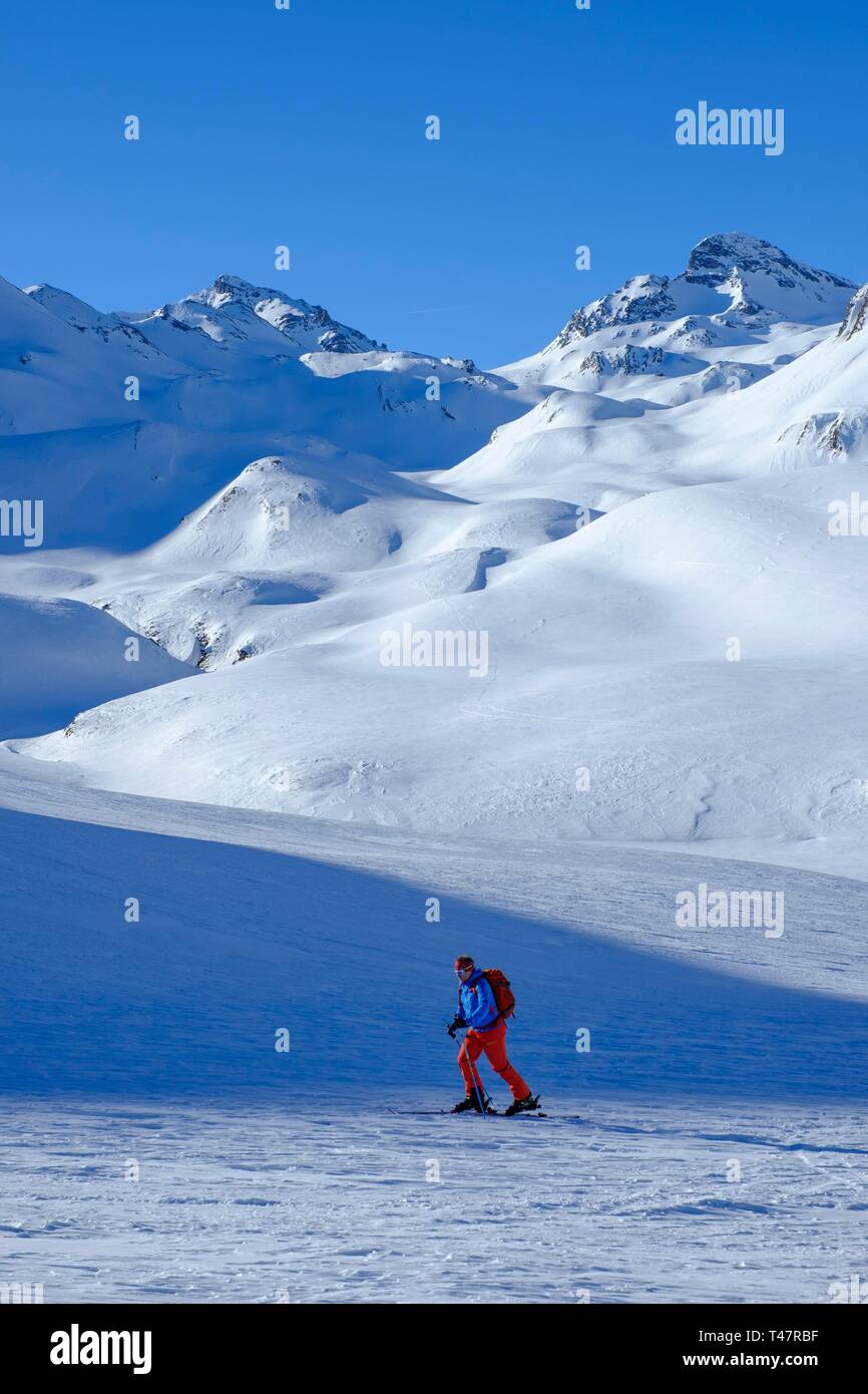 Skitourengeher aufsteigend Ils Chalcogens, im Hintergrund der Piz Tasna und breite Krone, Graubünden, Schweiz Stockfoto