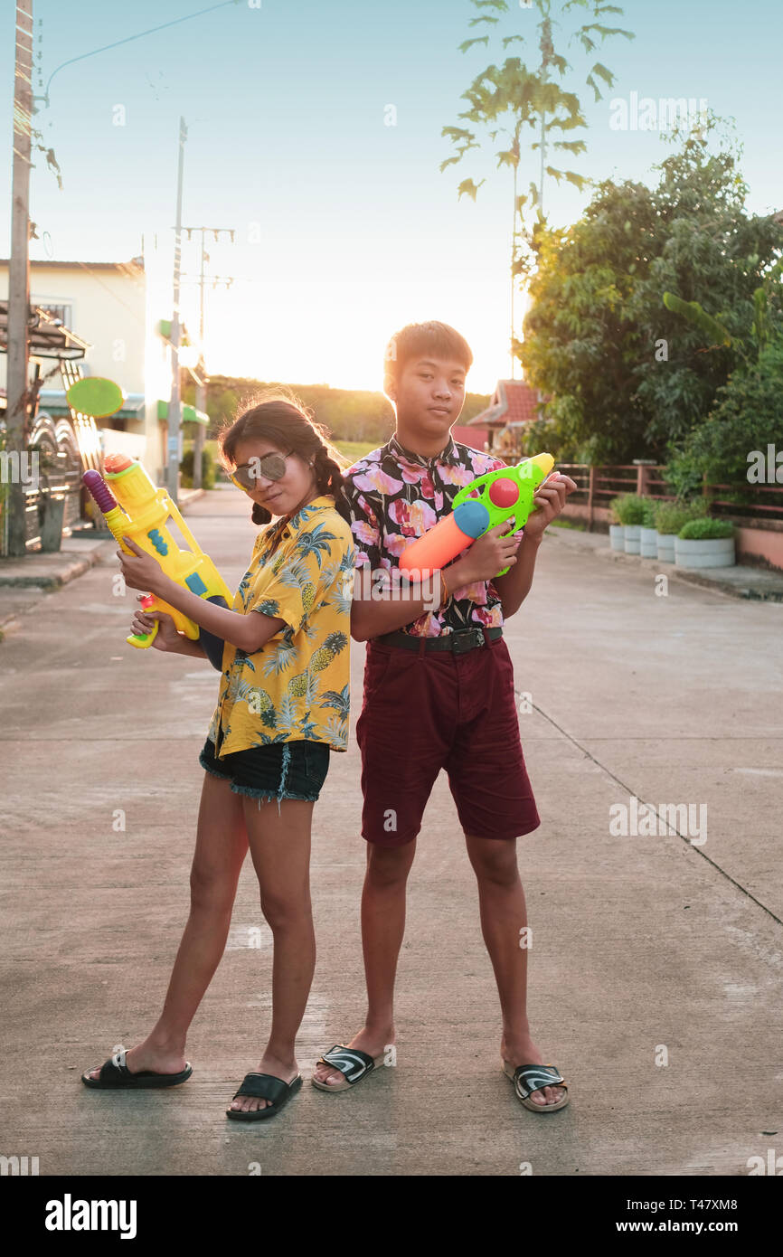 Junge und Mädchen spielen Wasserpistole zusammen auf Songkran Festival in Thailand Stockfoto