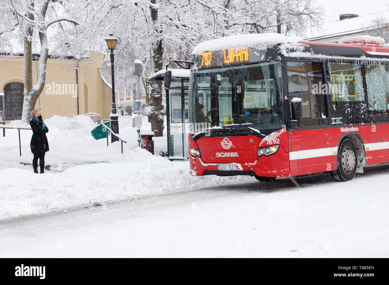 Södertälje, Schweden - Februar 3, 2019: Eine rote Öffentliche Verkehrsmittel Bus Service für SL in Zeile 787 bei einem Schneefall in der Nähe von der Hauptplatz der Stadt. Stockfoto