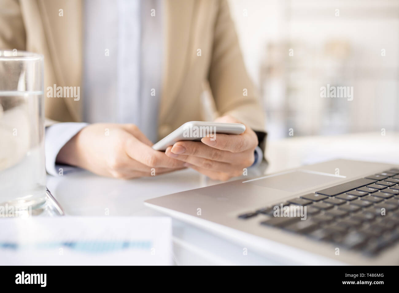 Eine Frau mit Handy am Arbeitsplatz Stockfoto