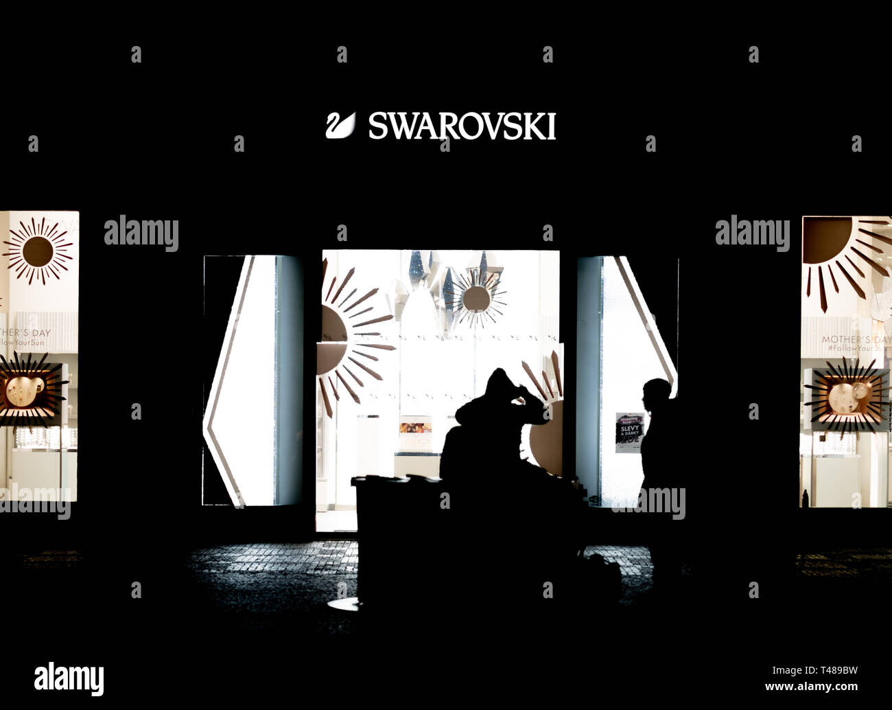 Prag, Tschechien - 10. APRIL 2019: Ein paar Vor einem Swarovski Shop sitzen spät in der Nacht in Prag Stockfoto