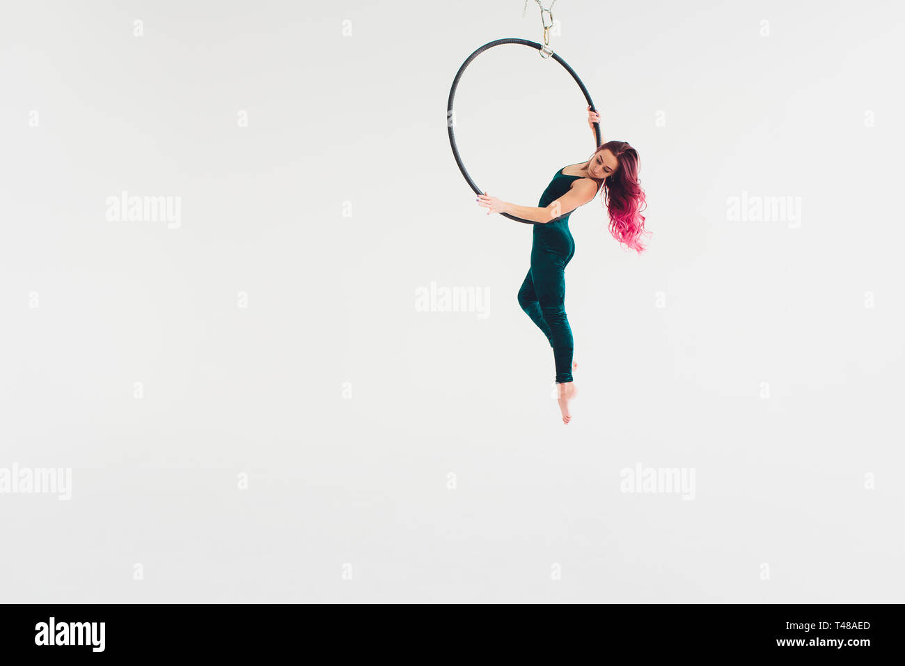 Ein junges Mädchen führt die akrobatische Elemente in der Luft. Studio shooting Leistungen auf einem weißen Hintergrund. Stockfoto