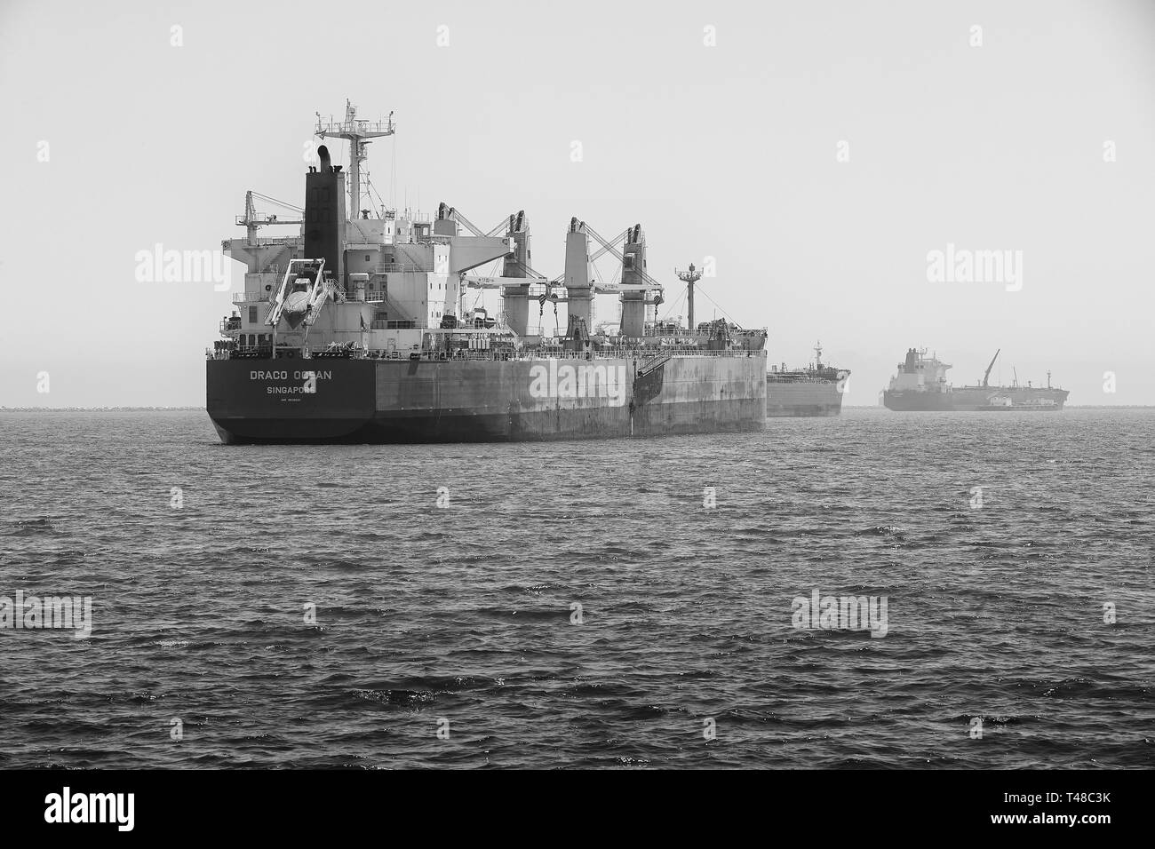 Schwarz-weiß Foto Der Bulk Carrier, DRACO OCEAN, vor Anker im Hafen von Long Beach, Kalifornien, USA. Stockfoto