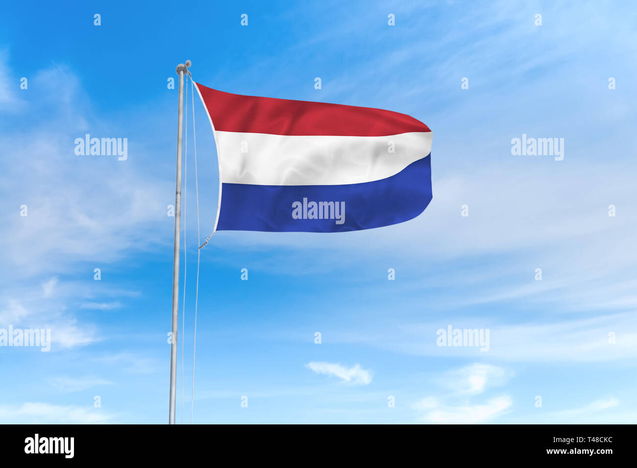 Niederlande Flagge weht im Wind über blauen Himmel Hintergrund Stockfoto