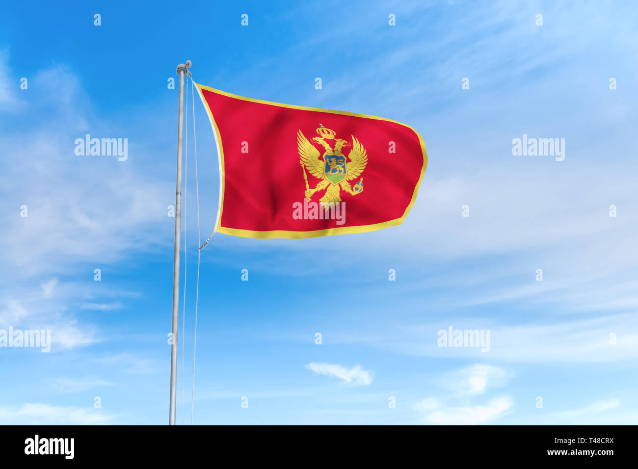 Montenegro Flagge weht im Wind über blauen Himmel Hintergrund Stockfoto