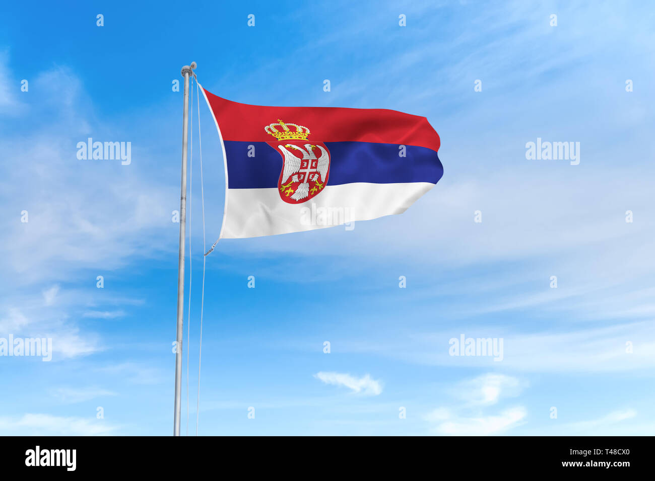 Serbien Flagge weht im Wind über blauen Himmel Hintergrund Stockfoto