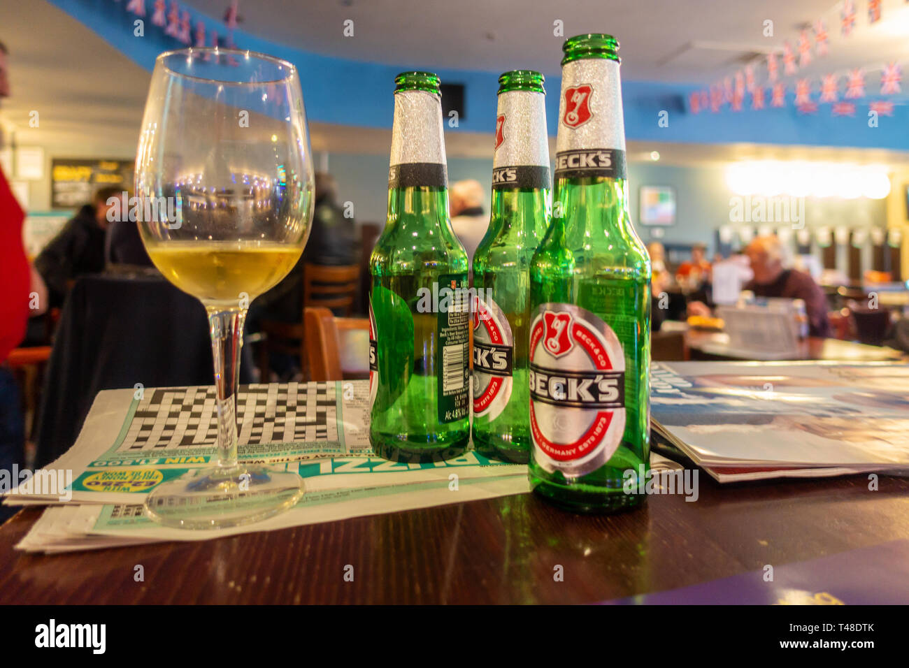 Glas Bier Flaschen und bei einem Glas Wein auf einem Tisch in einer Kneipe. Stockfoto