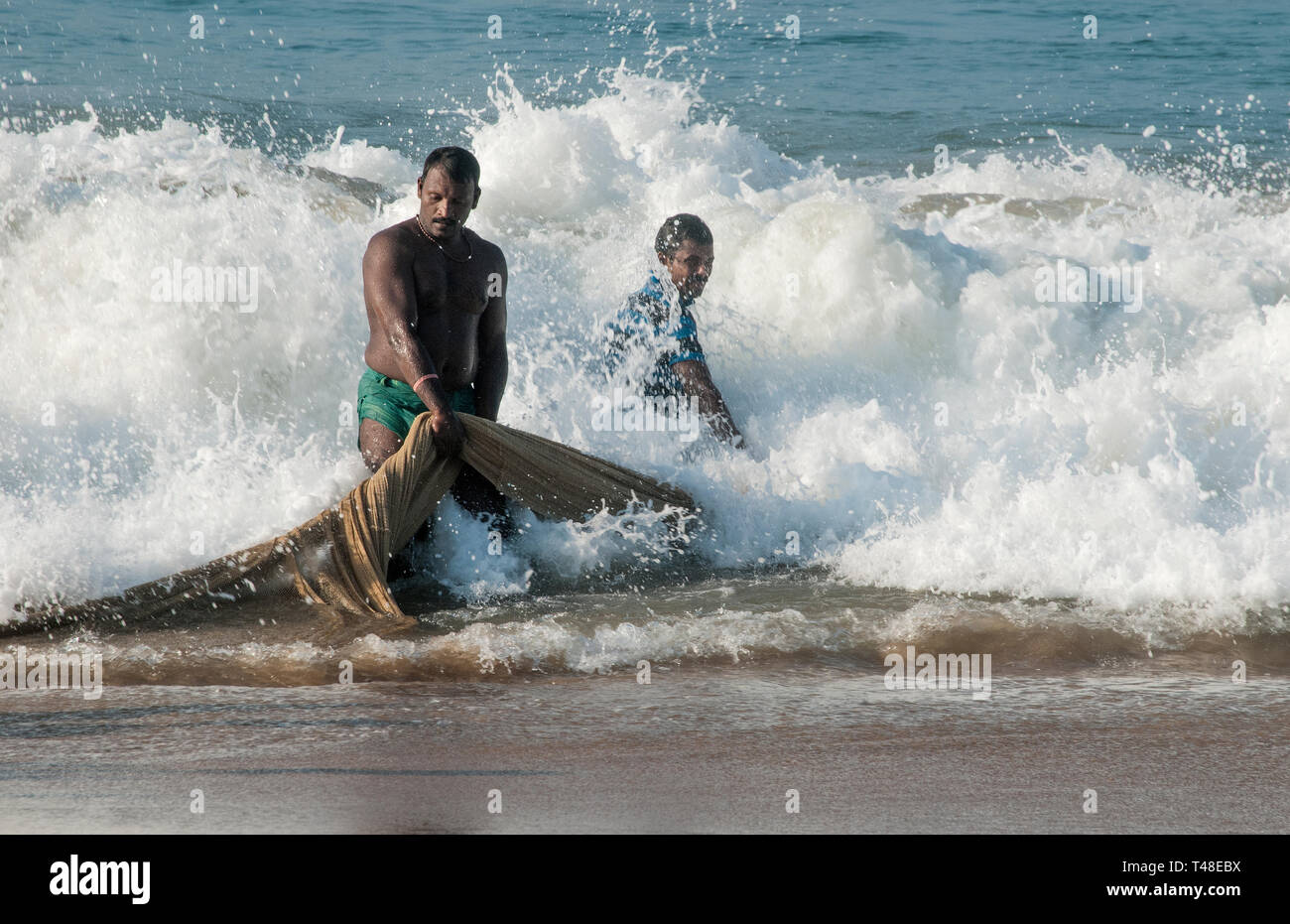 Indische Fischer in einem Fischernetz schleppen Stockfoto