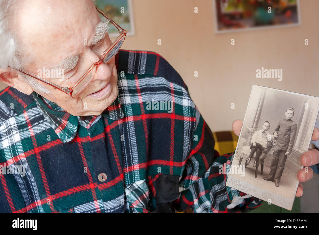 Senioren männliche Rentner ist glücklich auf dem Foto in seinem Zimmer zu sehen Stockfoto
