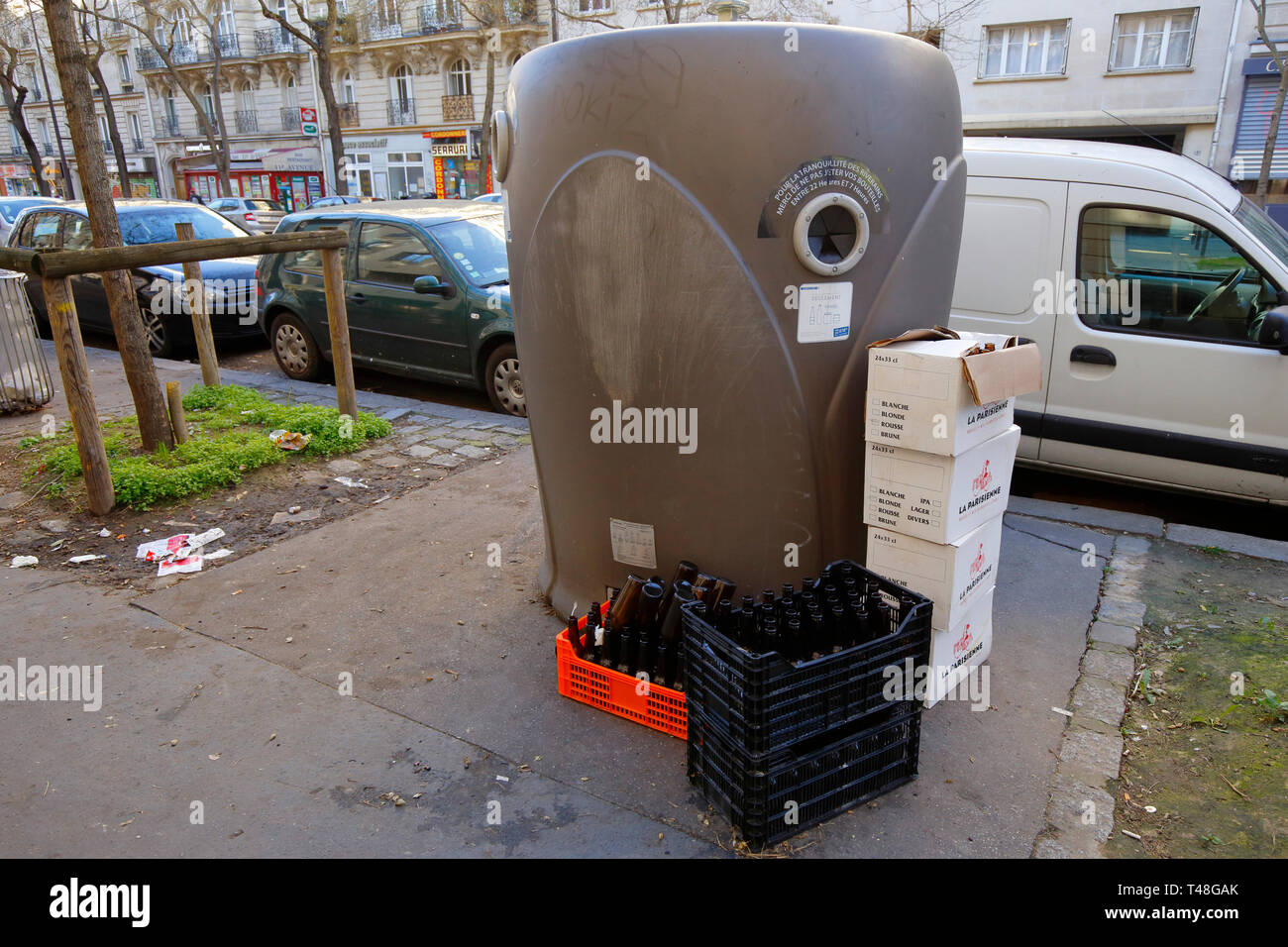 Ein Glas Papierkorb in Paris mit Ordentlich gestapelte Kisten überlauf Wertstoffe daneben, Paris, Frankreich Stockfoto