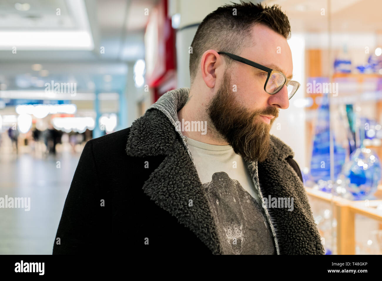 Weißer Mann mit Brille auf steht und schaut auf Produkte zum internationalen Flughafen in Prag - Tschechische Republik Stockfoto