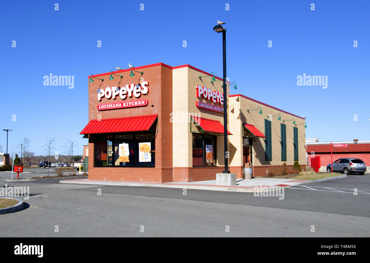 Popeyes Restaurant, einem US-amerikanischen Fast-Food-Kette bekannt für Southern Fried Chicken, Stoßfänger in New Bedford, Massachusetts, USA mit einem sonnigen klaren tiefblauen Himmel Stockfoto
