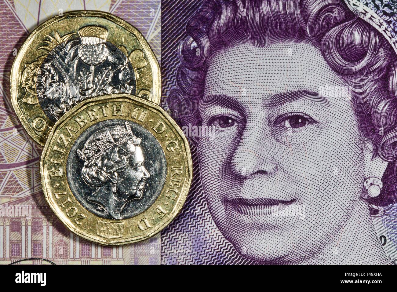 Neue ein Pfund Münzen auf einer zwanzig Pfund Banknote Stockfoto