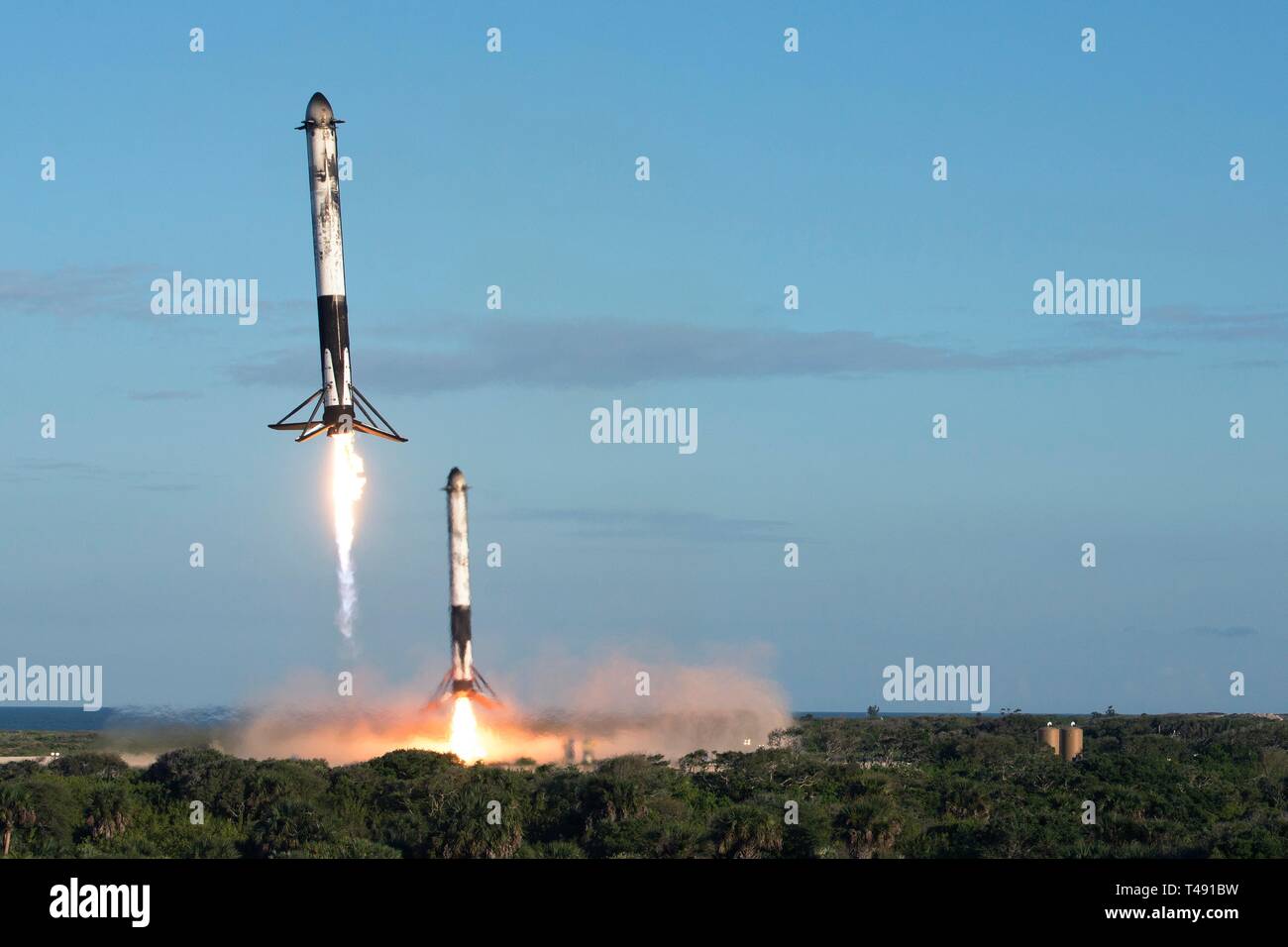 Zwei SpaceX Falcon Schwere wiederverwendbare Rocket Booster Land aufrecht nach Durchführung der saudi-arabischen Arabsat 6A communications Satelliten in eine Erdumlaufbahn vom Kennedy Space Center April 11, 2019 in Cape Canaveral, Florida. Dies ist der erste kommerzielle Start der massiven 27-Motor Koloss, der derzeit leistungsstärkste Rakete jetzt auf der Erde. Stockfoto