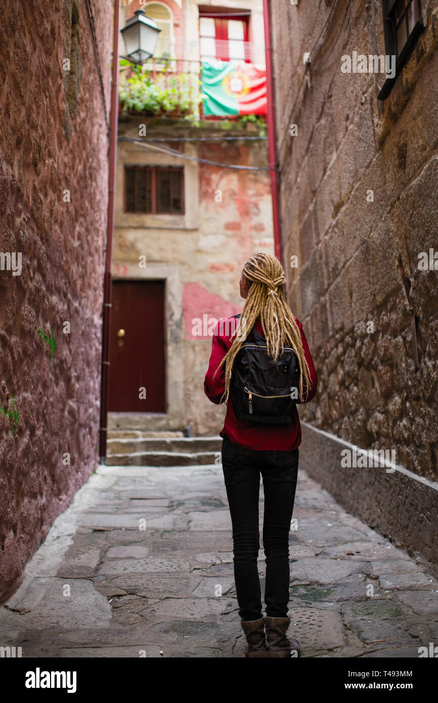 Junge Frau mit blonden Dreadlocks erforscht alte Portugiesische Stadt. Stockfoto
