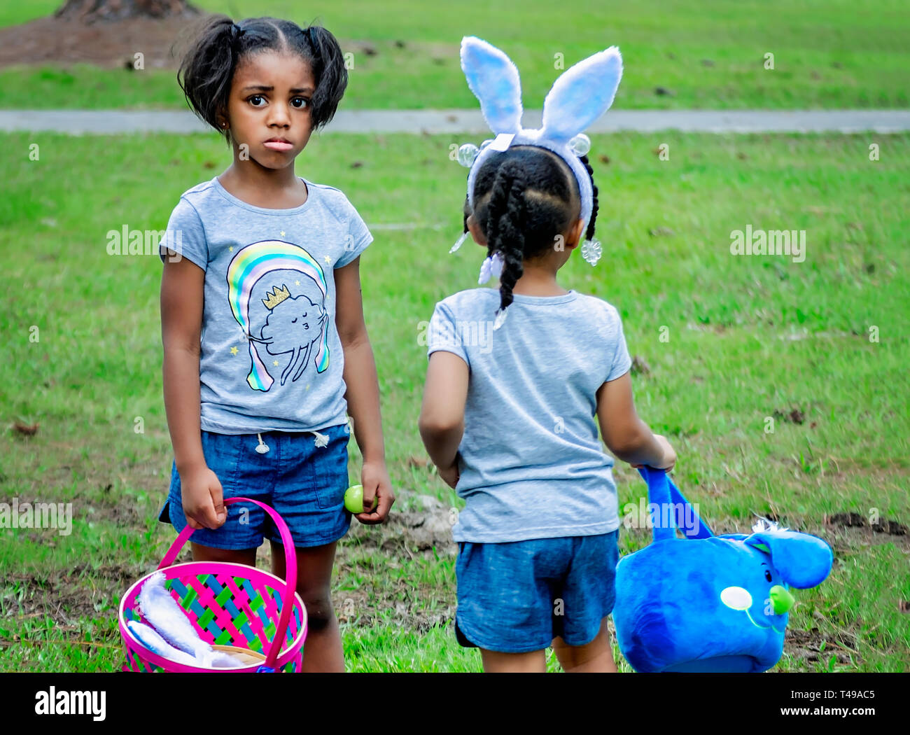 Die Schwestern versuchen, zu entscheiden, welche Richtung während einer Gemeinschaft Ostereiersuche am Langan Park, April 13, 2019 in Mobile, Alabama. Stockfoto