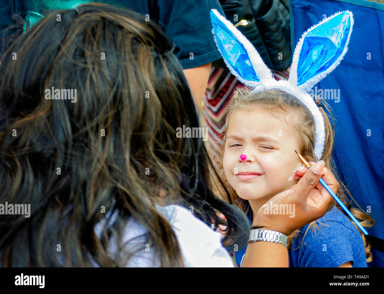 Ein Mädchen Grimassen, als Sie Ihr Gesicht wird während einer Gemeinschaft Ostereiersuche am Langan Park, April 13, 2019 in Mobile, Alabama, lackiert. Stockfoto