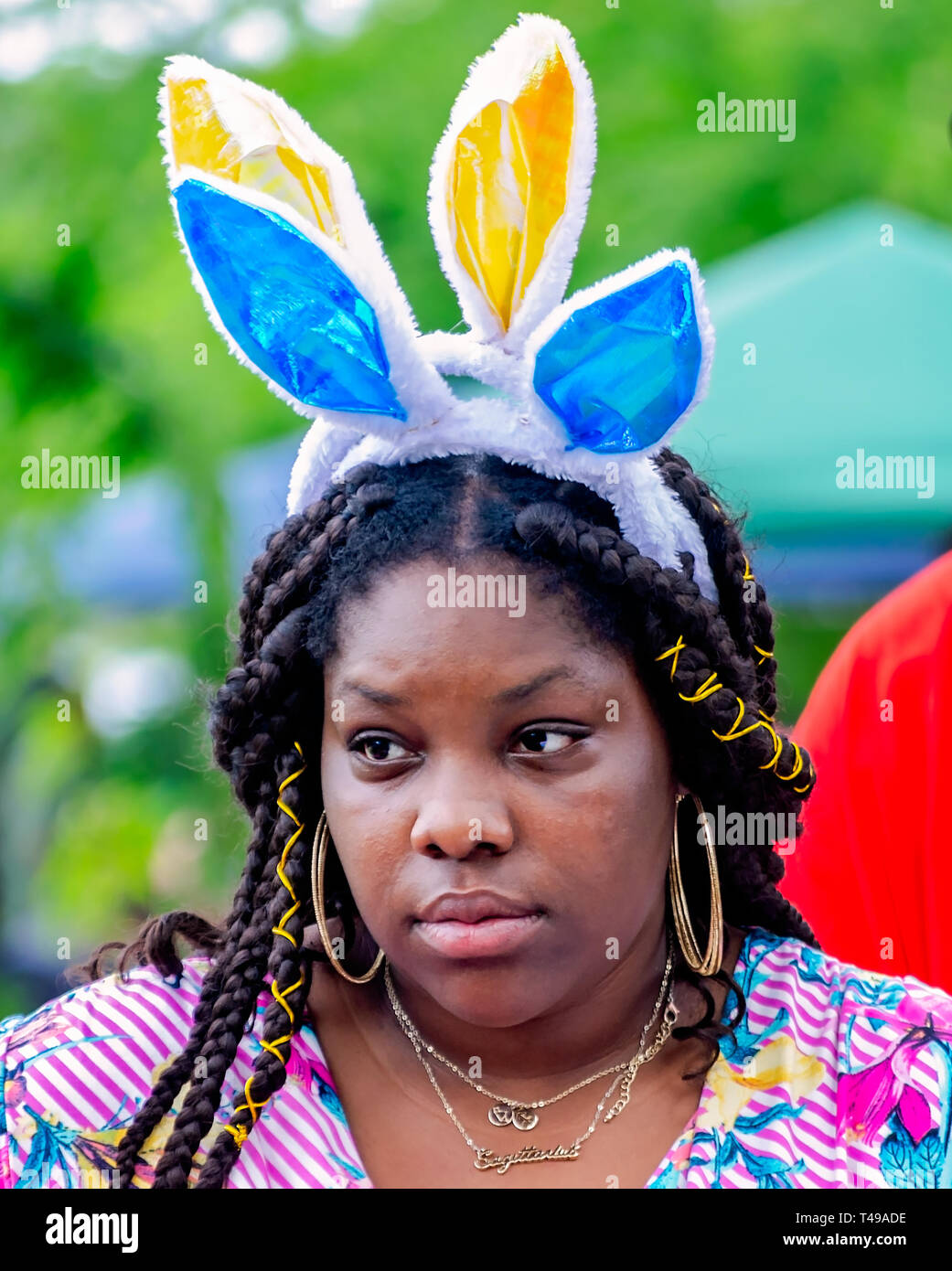 Eine Frau trägt bunny Ohren während einer Gemeinschaft Ostereiersuche am Langan Park, April 13, 2019 in Mobile, Alabama. Stockfoto