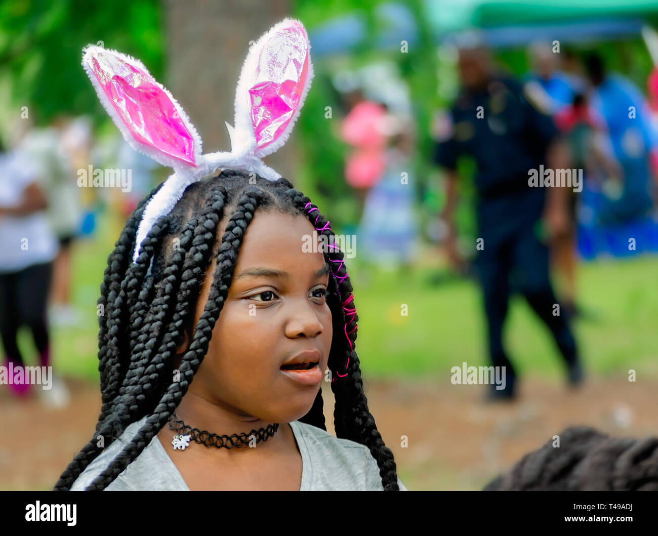 Ein Mädchen trägt bunny Ohren während einer Gemeinschaft Ostereiersuche am Langan Park, April 13, 2019 in Mobile, Alabama. Stockfoto