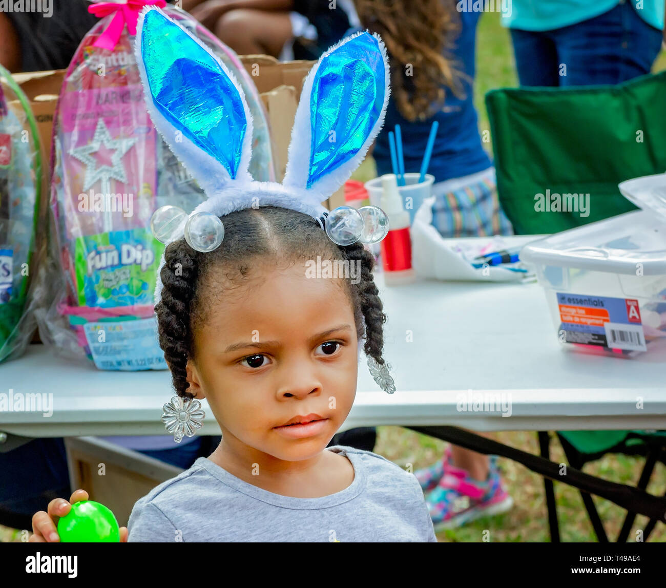 Ein Mädchen beobachtet die anderen Kinder während einer Gemeinschaft Ostereiersuche am Langan Park, April 13, 2019 in Mobile, Alabama. Stockfoto