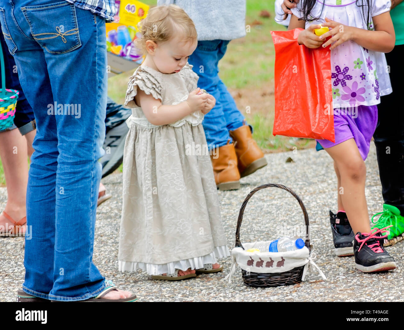 Ein Kind hält den Inhalt einer Kunststoff Osterei während einer Gemeinschaft Ostereiersuche am Langan Park, April 13, 2019 in Mobile, Alabama, zu prüfen. Stockfoto