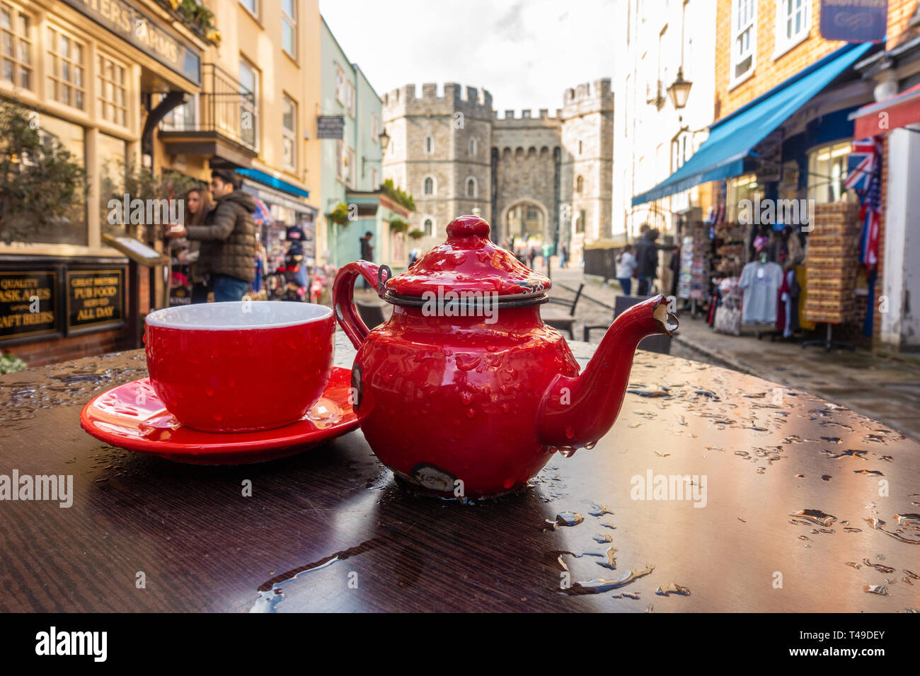 Eine helle rote Teetasse, Untertasse und Teekanne bilden einen Blickfang Mittelstück auf ein Café im Freien Tisch in der Church Street, Windsor, Großbritannien Stockfoto