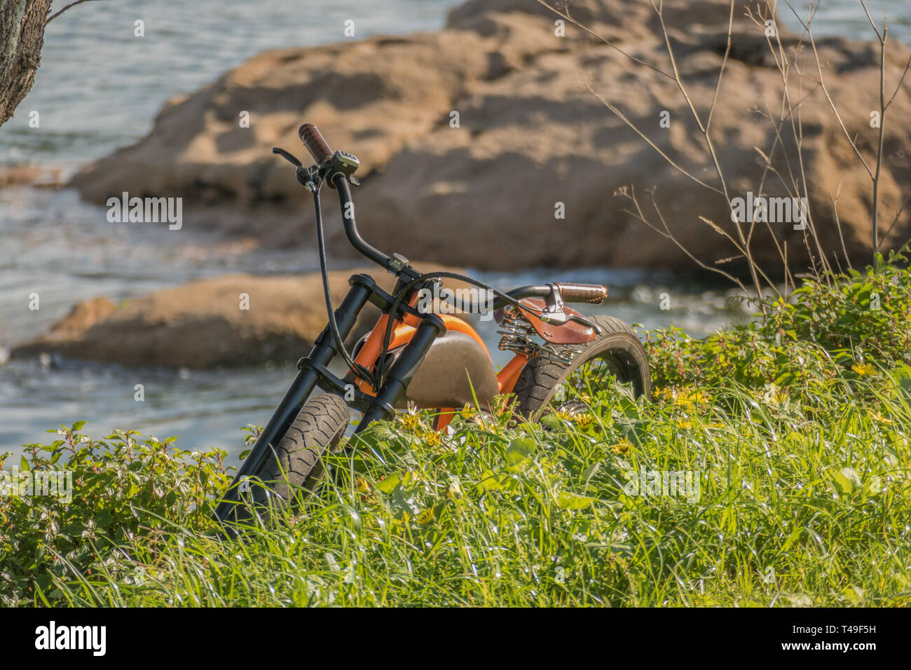 Blick auf dem Fahrrad auf dem Gras mit Felsen und Meer im Hintergrund Stockfoto
