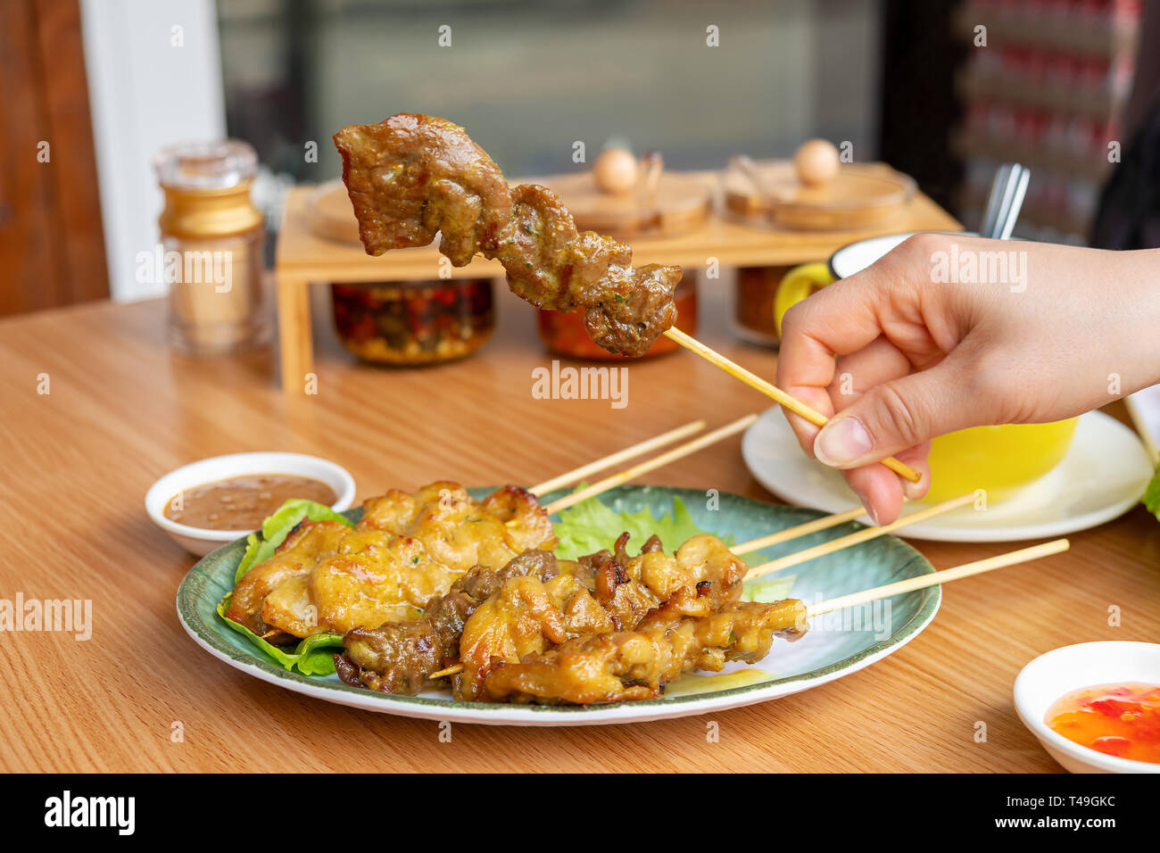 Frau Hand hält eine Stücke von Satay Stockfoto
