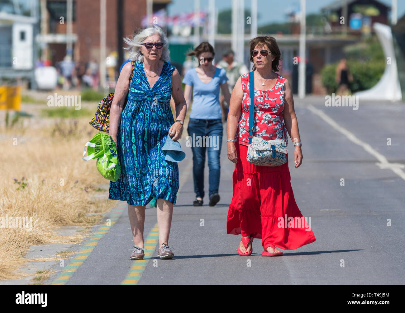 Vorderansicht des ein Paar im mittleren Alter Frauen zusammen zu Fuß in Richtung der Kamera entlang der Strandpromenade in Littlehampton, West Sussex, England, UK. Stockfoto