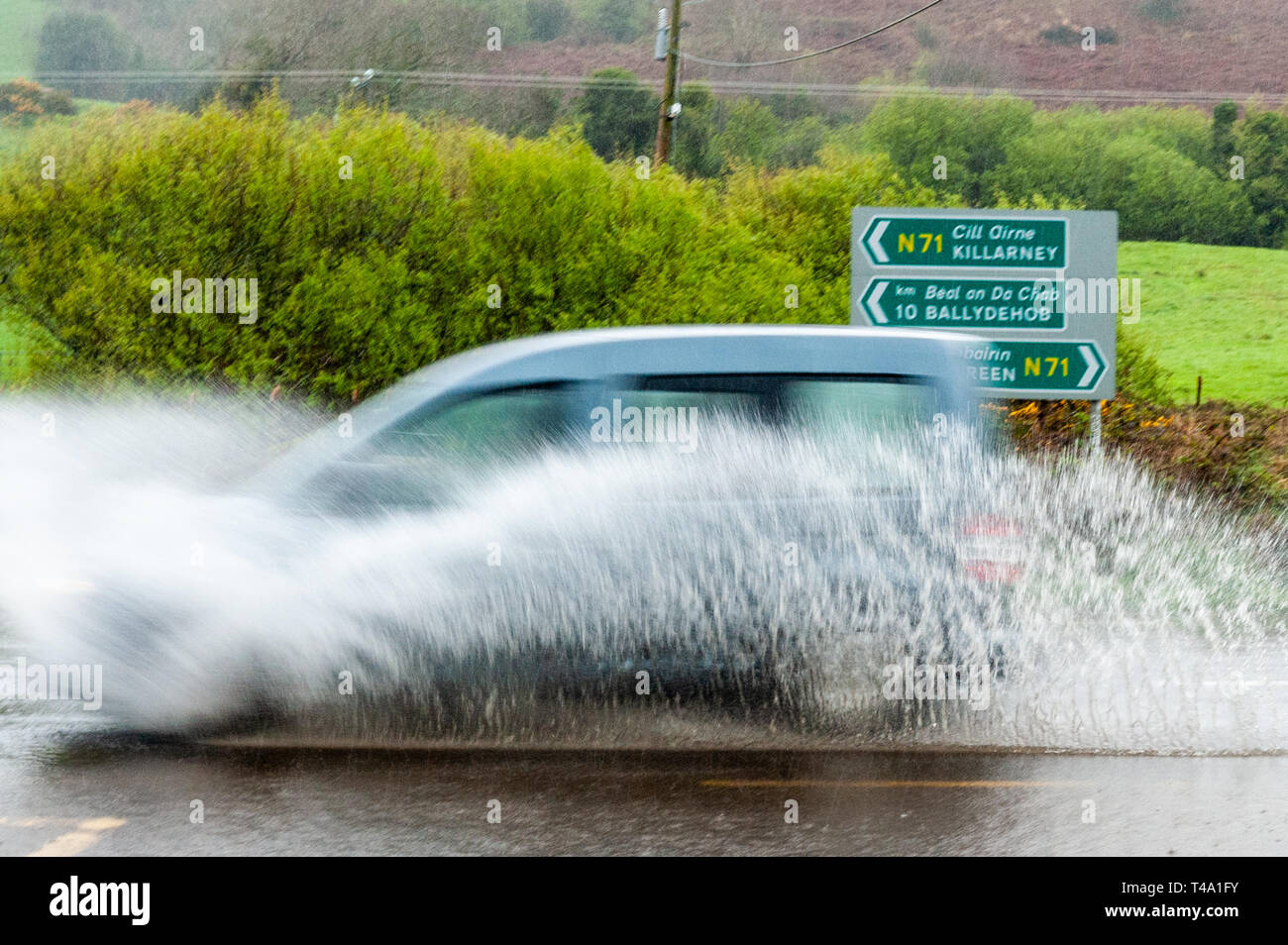 Skibbereen, West Cork, Irland. 15 Apr, 2019. Viel in Irland befindet sich mitten in einem Status Orange Niederschlag Warnung, ausgestellt von Met Éireann. Ein Auto Rennen durch einen Punkt Flut auf der N71 in der Nähe von Skibbereen. Credit: Andy Gibson/Alamy leben Nachrichten Stockfoto