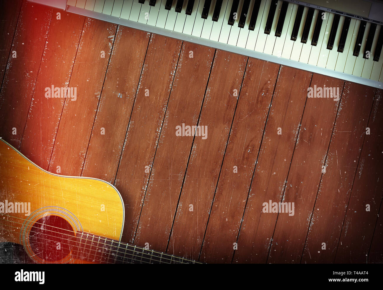 Musikinstrument - Sloseup MIDI Piano 61 Tasten Keyboard und Akustikgitarre auf einem hölzernen Hintergrund Stockfoto