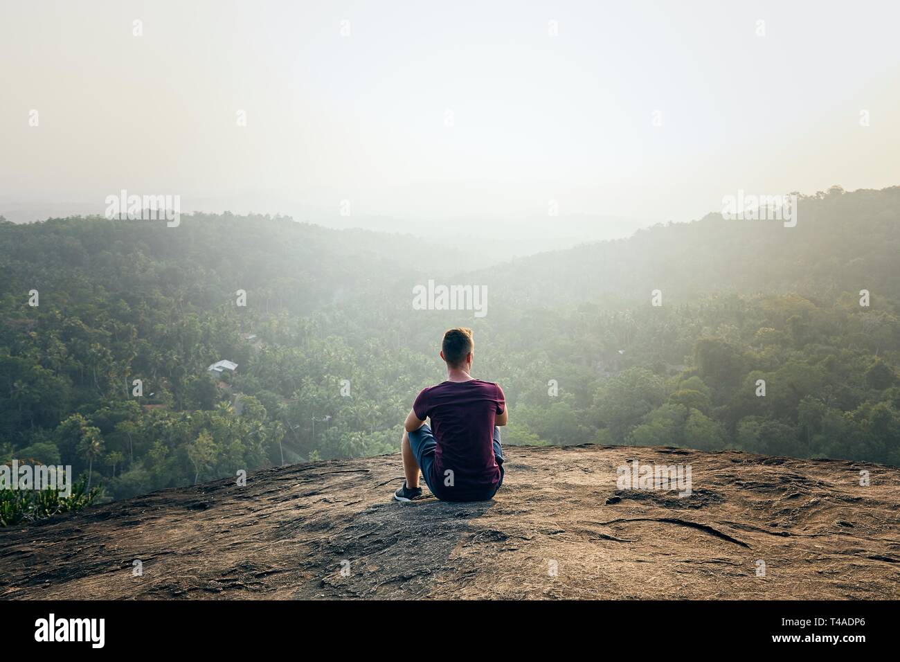 Junge Menschen, die auf der Oberseite von Rock. Landschaft im Nebel Sonnenuntergang in Sri Lanka. Stockfoto