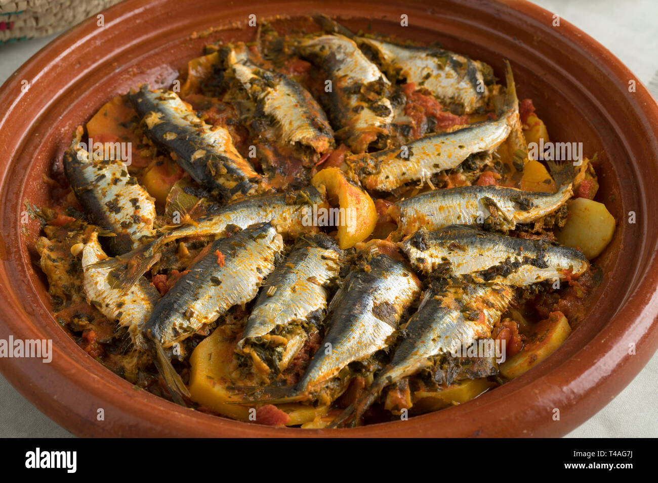 Traditionelle marokkanische Tajine mit Sardinen und Gemüse auf dem Tisch für das Abendessen Stockfoto