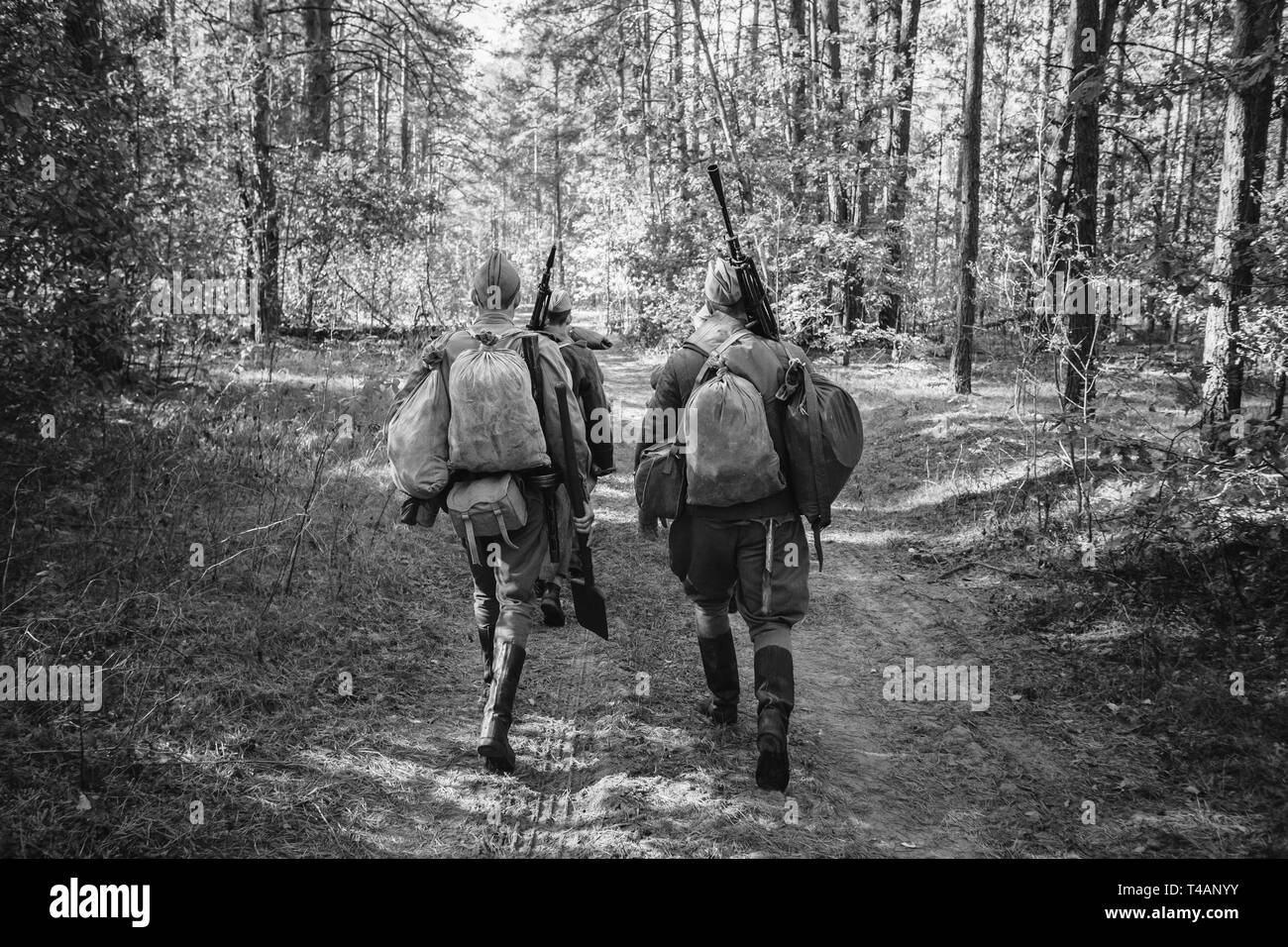 Zwei Re-enactors als Zweiter Weltkrieg russisch-sowjetischen Soldaten der Roten Armee Marschieren durch den Wald gekleidet. Foto in den Farben Schwarz und Weiß. Soldat des zweiten WELTKRIEGS WW2 Stockfoto