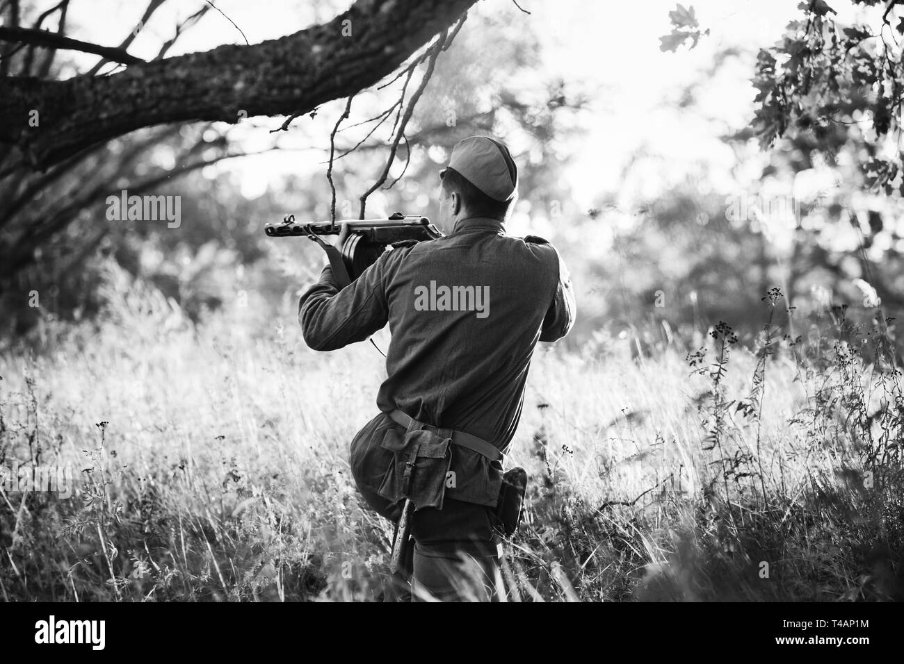Re-Enactor gekleidet, wie sowjetische Rote Armee Soldat mit dem Ziel, eine Maschinenpistole auf gegnerische. WWII WW2 Russian Intelligence Bereich. Foto in den Farben Schwarz und Weiß. Stockfoto