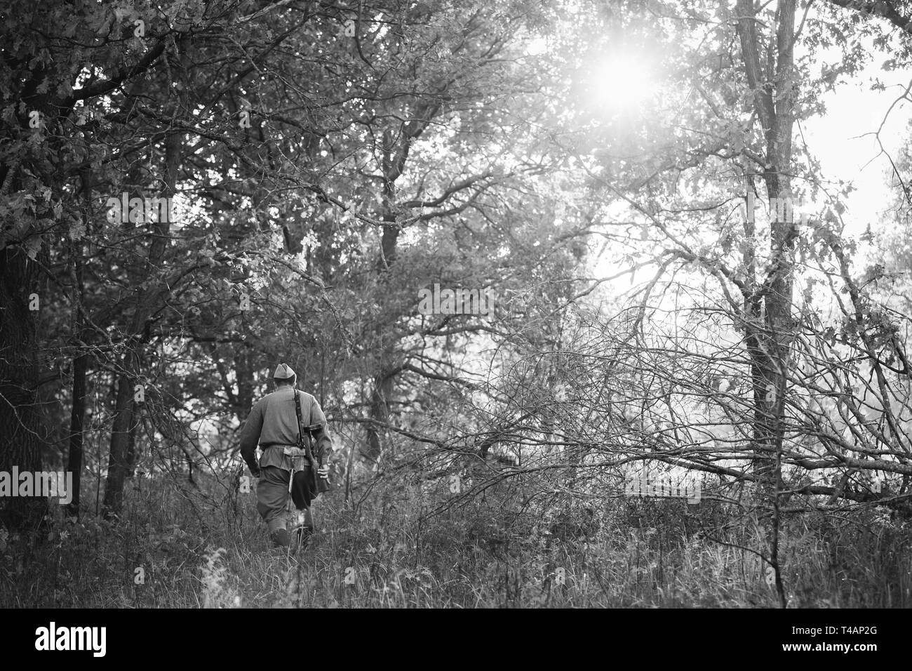 Re-Enactor gekleidet als Zweiter Weltkrieg russisch-sowjetischen Roten Armee Soldat mit Waffe durch Wald. Soldat des zweiten WELTKRIEGS WW 2 Mal. Foto In Blac Stockfoto