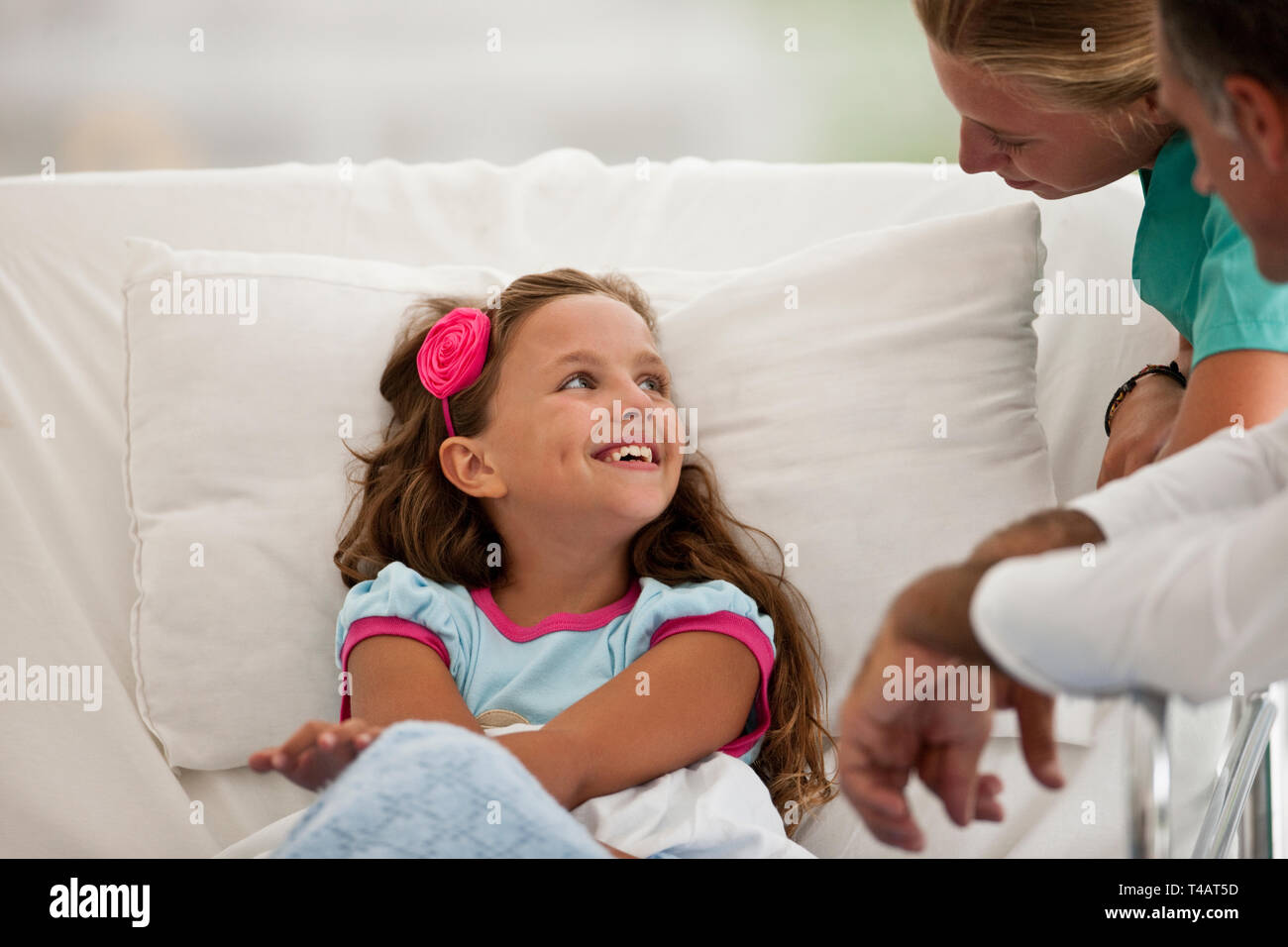 Junge Mädchen in einem Krankenhausbett, im Gespräch mit Ihrem Arzt und Krankenschwester. Stockfoto