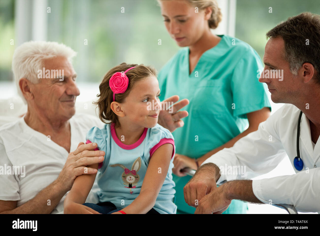 Ältere Menschen, die einen Besuch im Krankenhaus von seiner Enkelin. Stockfoto