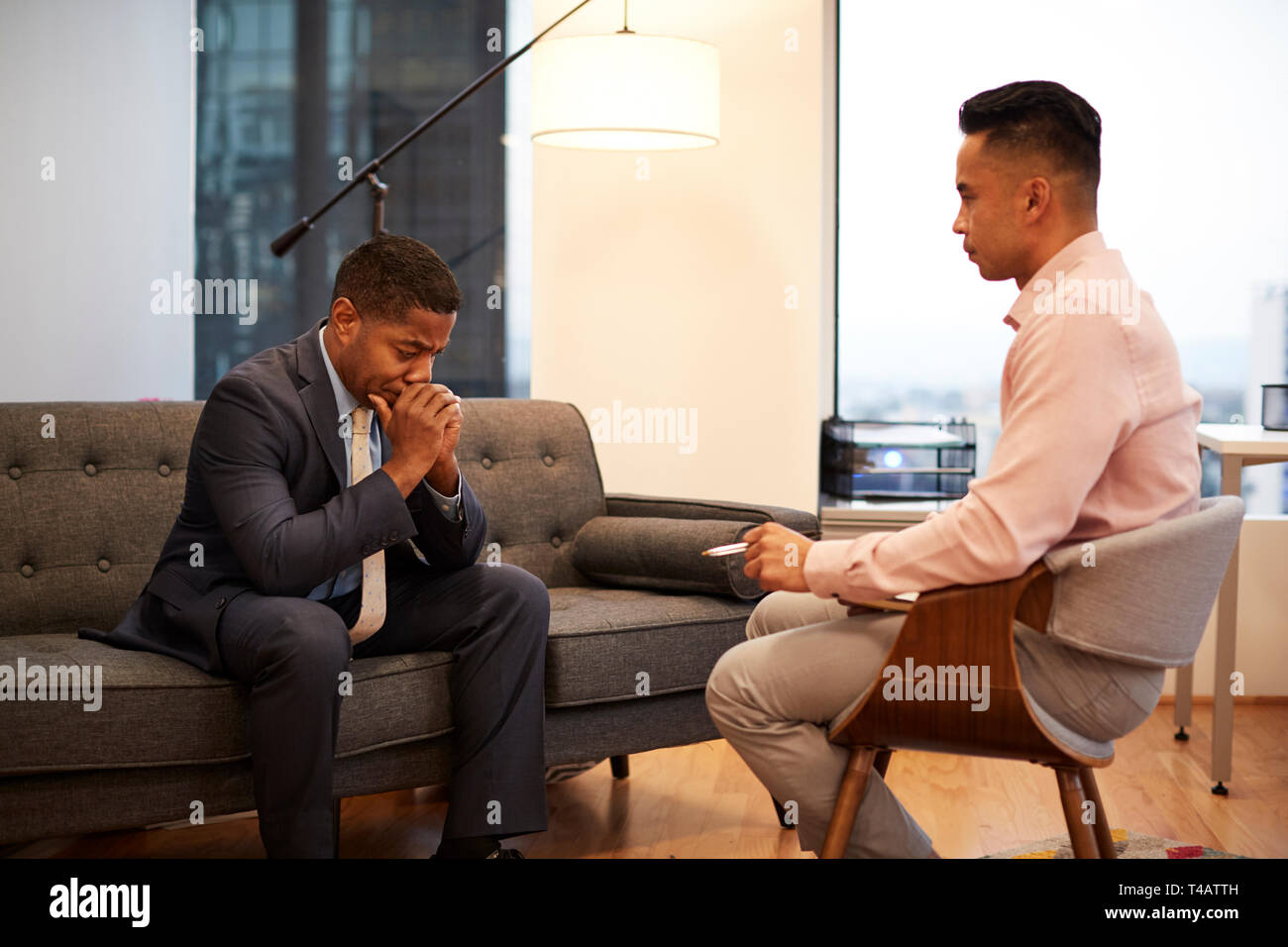 Unglücklich, Geschäftsmann, Sitzen auf der Couch treffen mit männlichen Ratgeber in Office Stockfoto